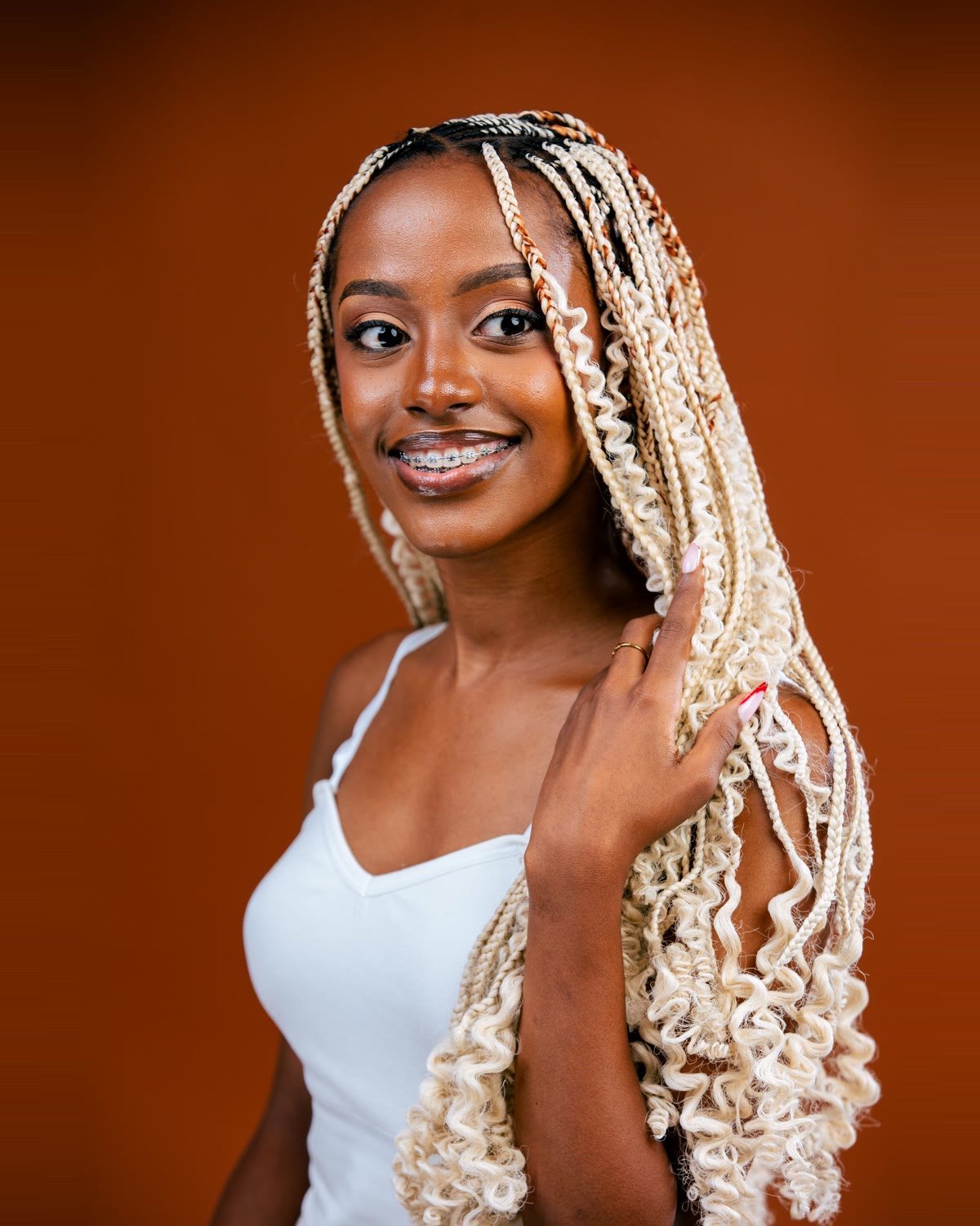 Model wearing long blonde Aunty's Braid with loose curls