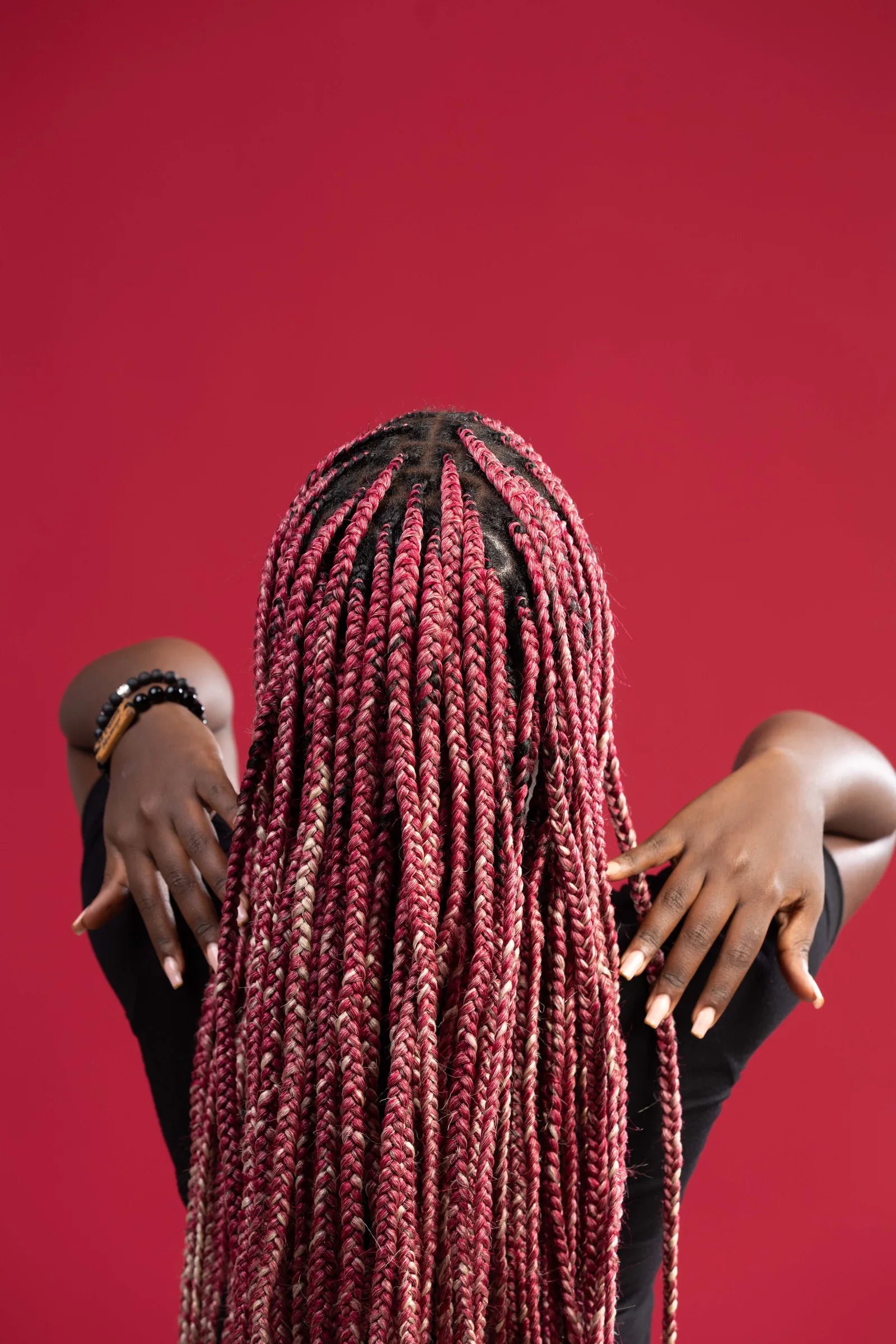 Close view of pink blend braids against a pink background
